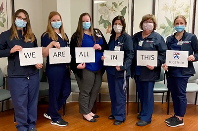 6 nurses holding signs that say "We Are All In This Together"